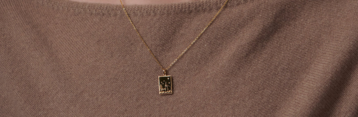 a young woman wearing a london city landmark postcard necklace