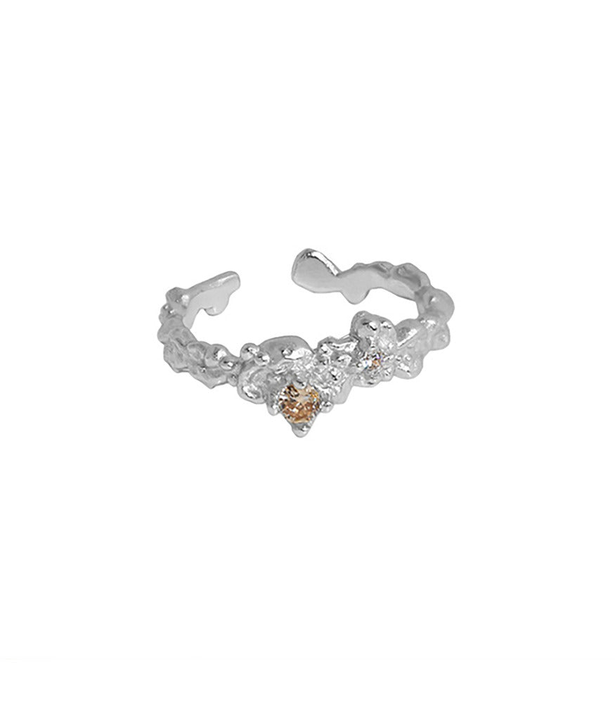 A sterling silver ring. The ring is textured, with an open band design and a champagne gold gemstone.