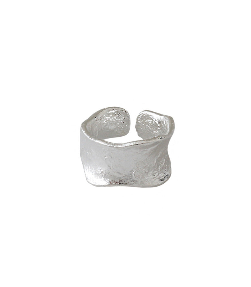 A sterling silver ring with a concave thick open band. The ring has a brushed texture.