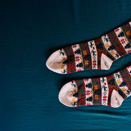 A pair of patterned socks in red, cream and green.
