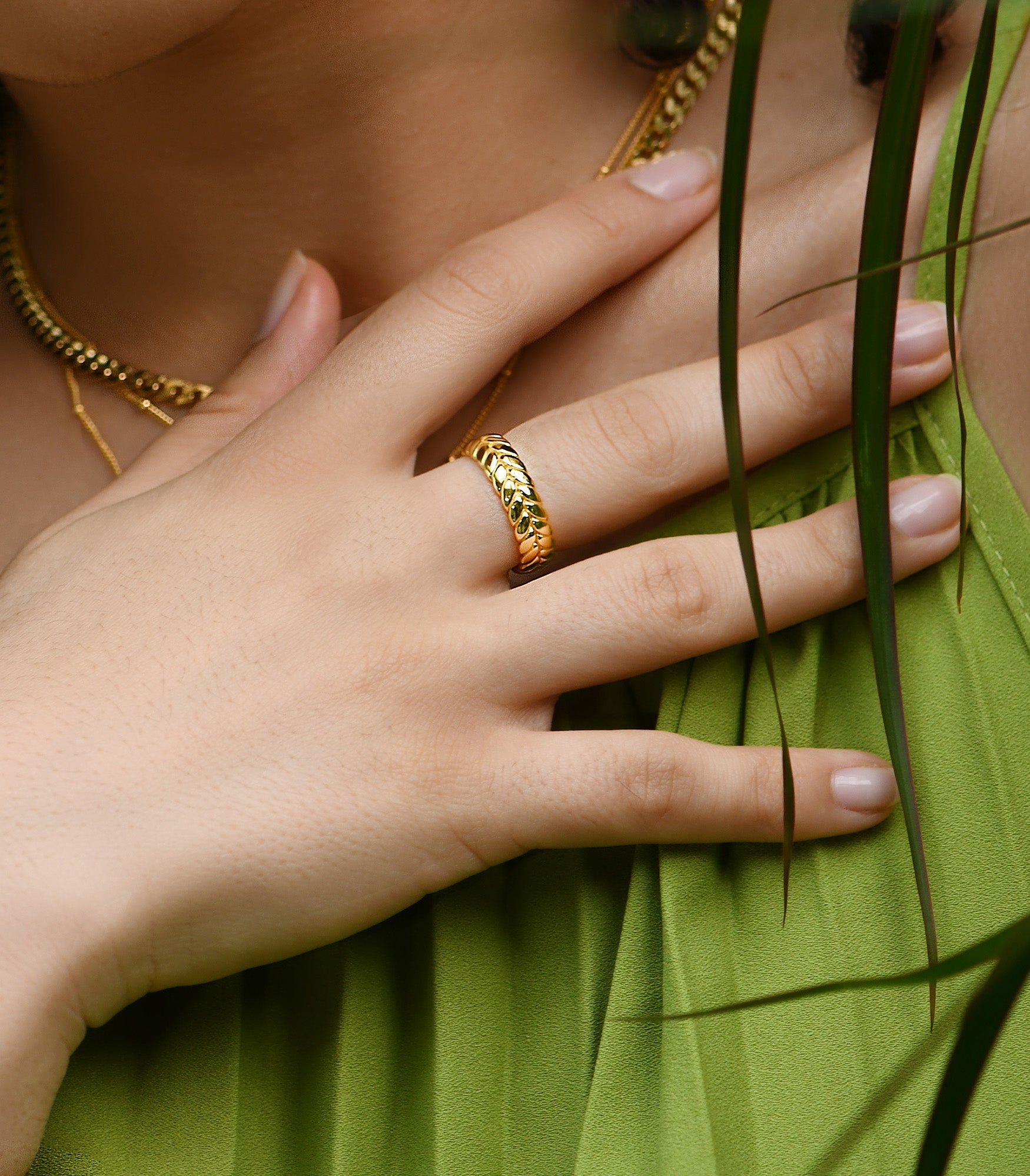 A female model wearing a wheat patterned chunky ring band in gold vermeil