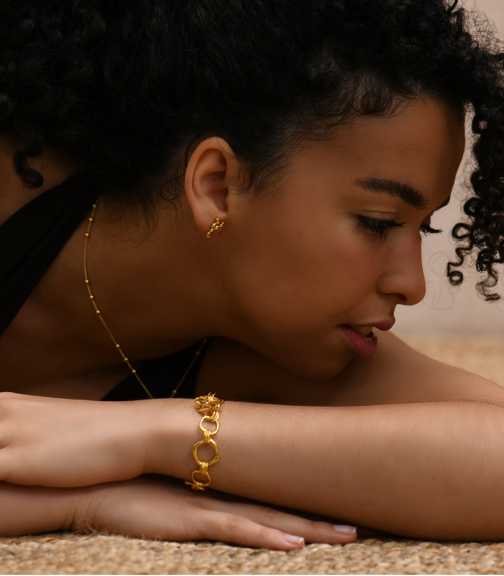 a well polished gold vermeil circle link bracelet worn on a tanned skin female model