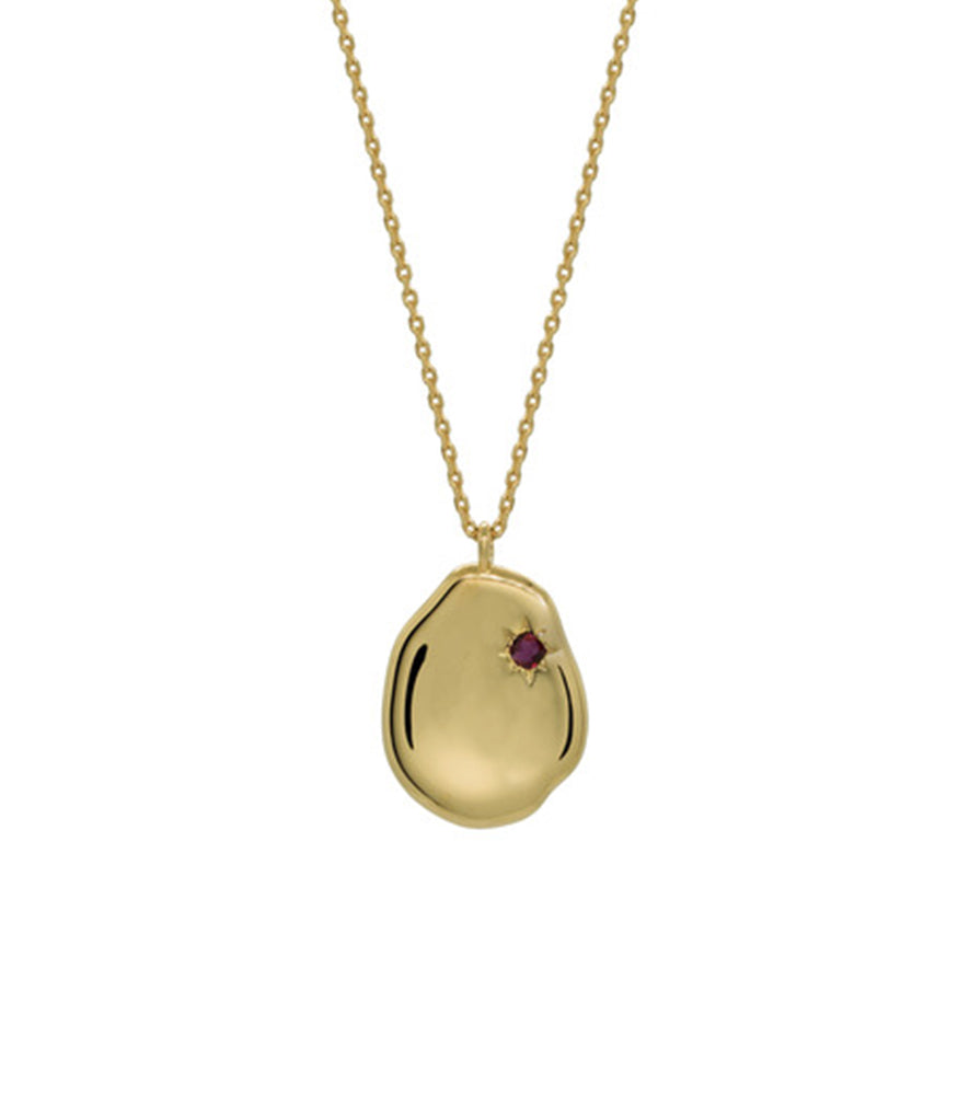 A gold vermeil necklace with a dainty gold chain and a pendant featuring a ruby stone.