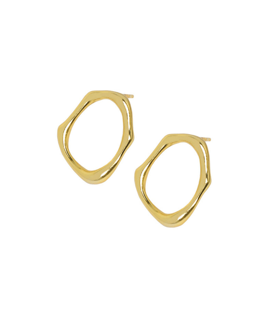 A pair of irregular shaped, gold vermiel circle stud earrings. The earrings shape resembles the movement of flowing water.