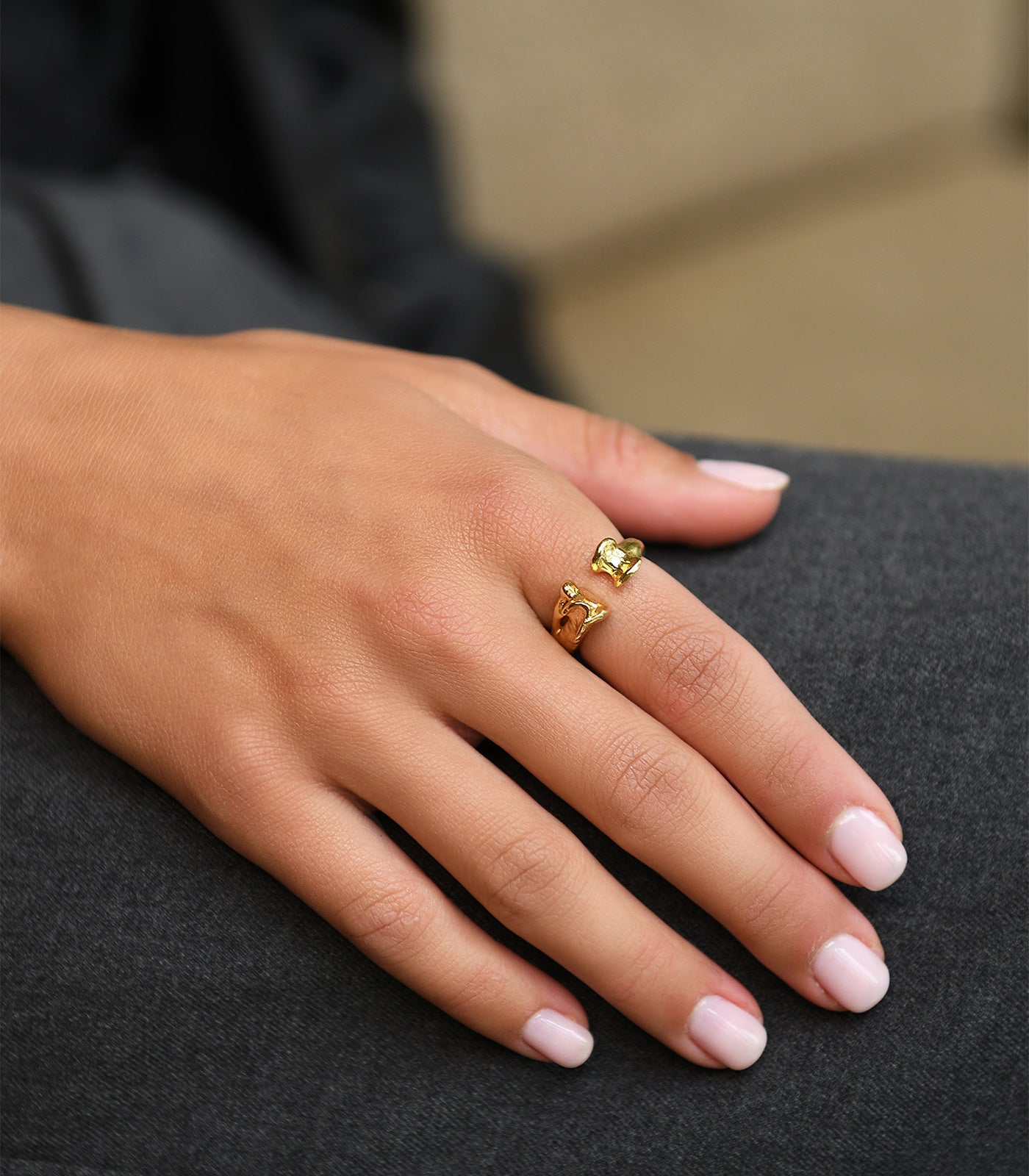 A model wears a gold vermeil, open band ring. The ring has a bone detailing at the end of each side of the band.