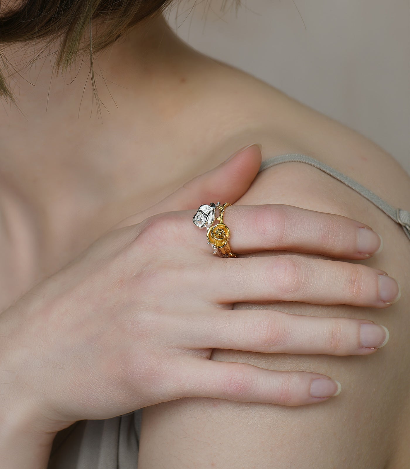 A gold vermeil ring with a thorn detailing on the band and a rose design on the top of the ring.