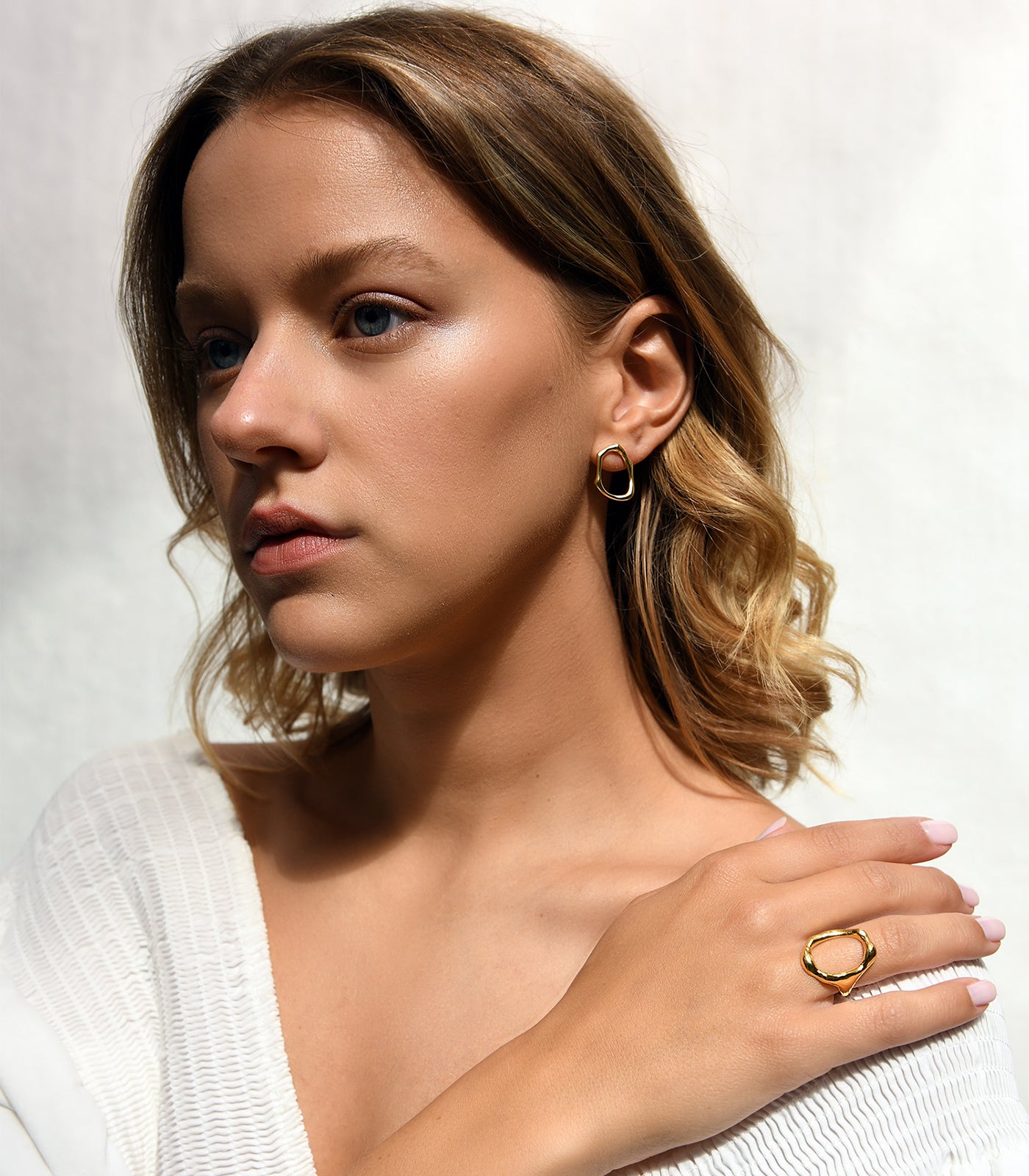 A model wearing a gold vermeil circle stud earring. The circle is irregularly shaped.
