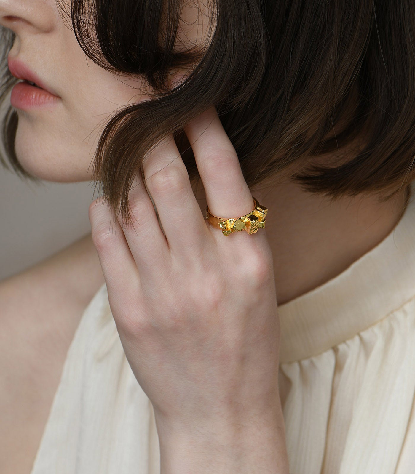 A gold vermeil, open band ring with a rocky cobble detailing.