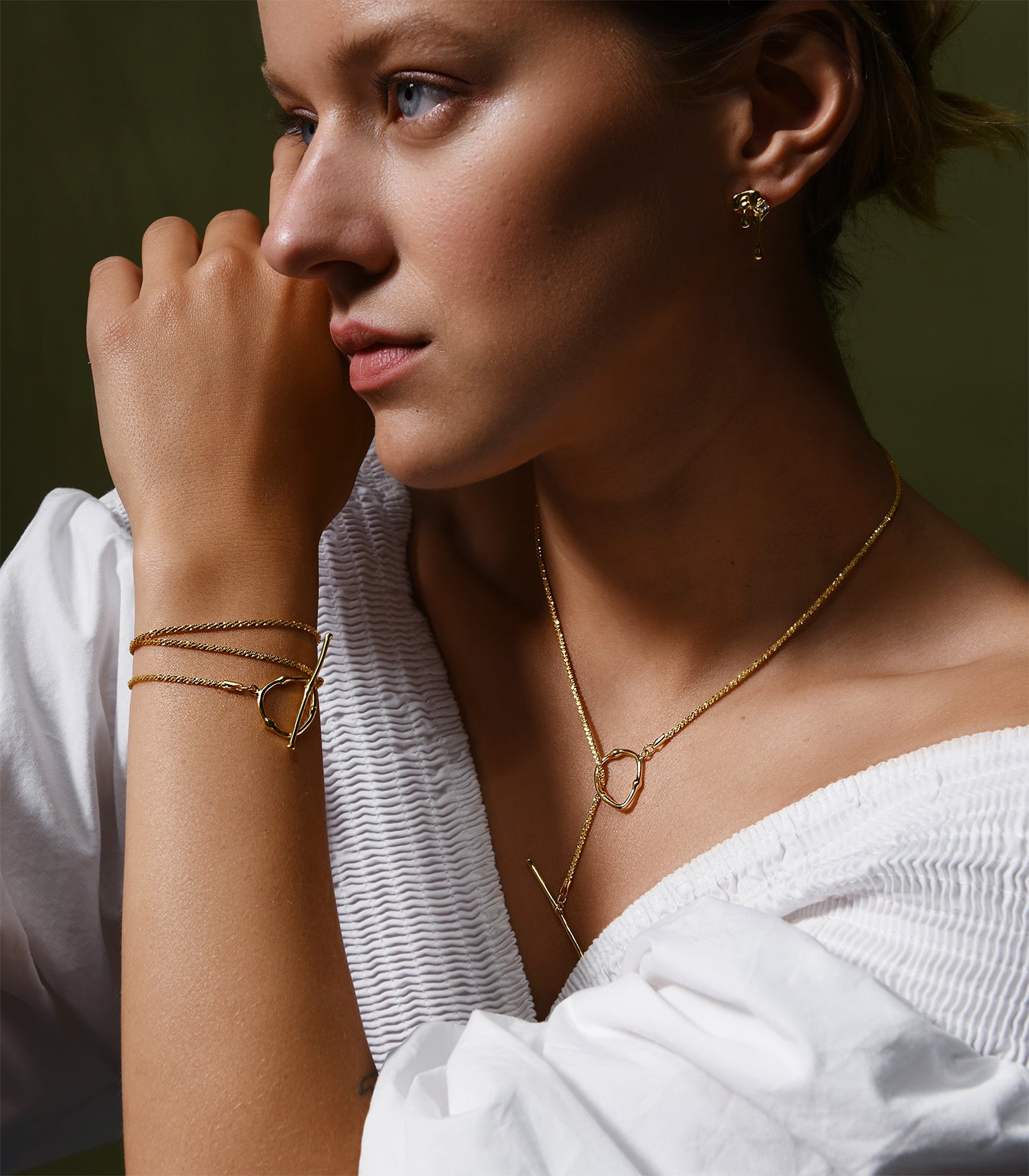 A lady wearing a gold vermeil toggle clasp necklace with a matching toggle clasp bracelet.