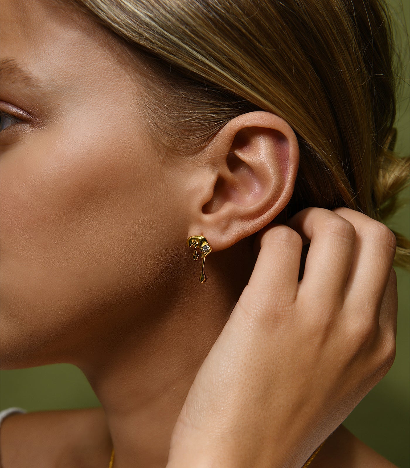 A pair of gold vermeil, water droplet earrings with a sparkling gem stone.