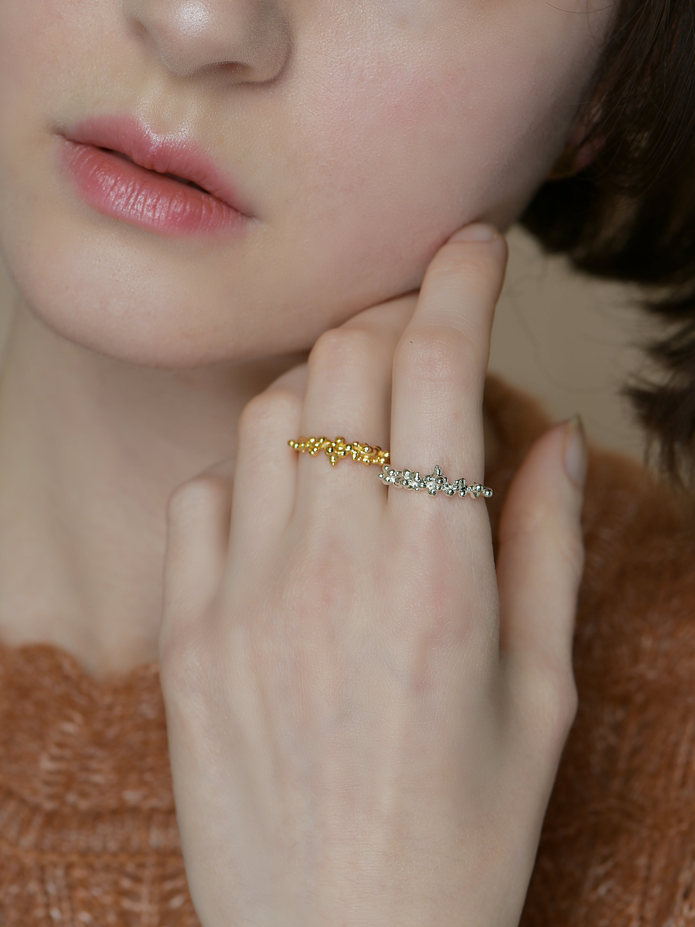 A model wears two rings, one sterling silver and the other a gold vermeil. Both rings have a bubble texture design.