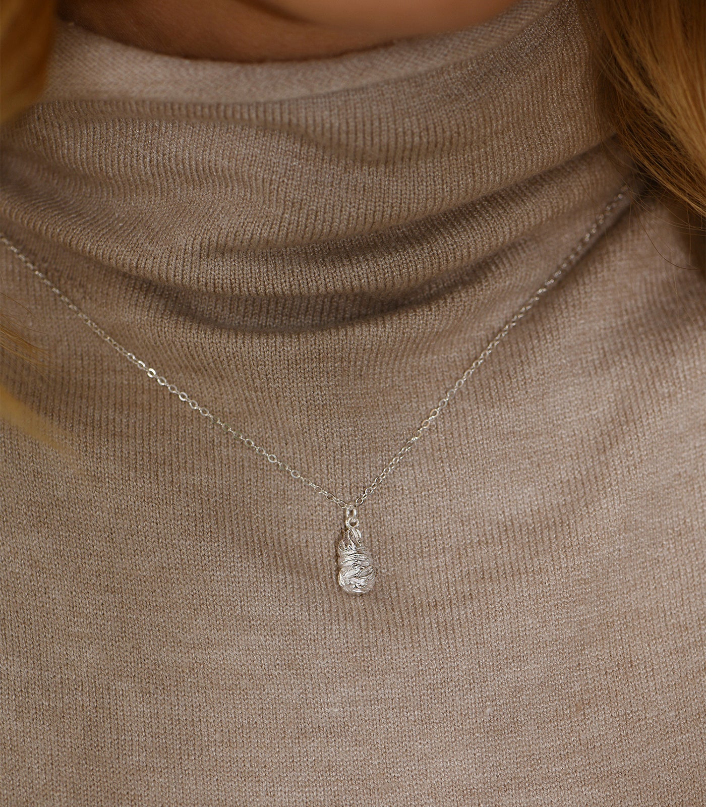 A model wears a sterling silver necklace with a nugget pendant.