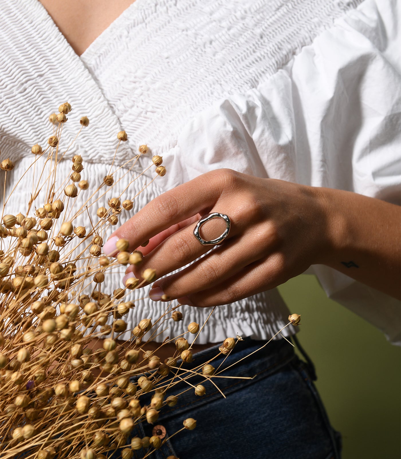 A model wears a sterling silver ring with an oval shape design at the front.