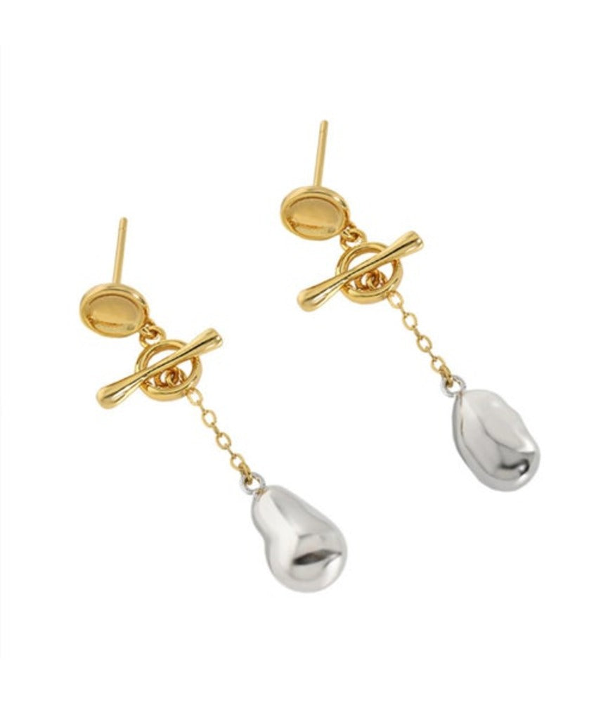 A pair of mixed metal earrings with a toggle clasp and a pair of sterling silver nuggets delicately hanging from the toggle clasp.