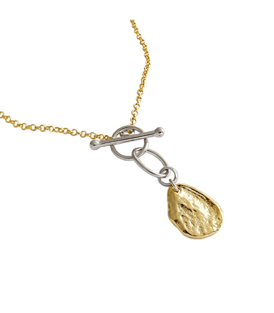 A necklace with a gold chain and a sterling silver toggle clasp holding a gold plated nugget.