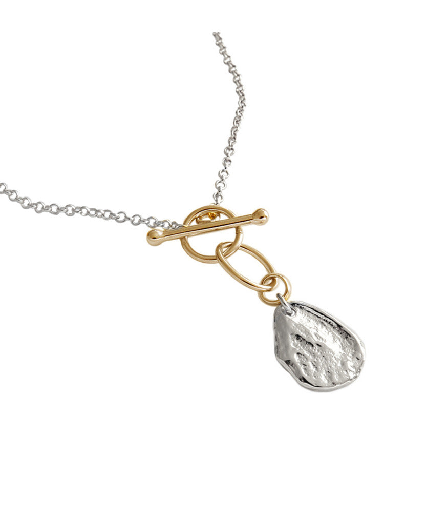 A necklace with a sterling silver chain and gold plated toggle clasp holding a silver nugget.