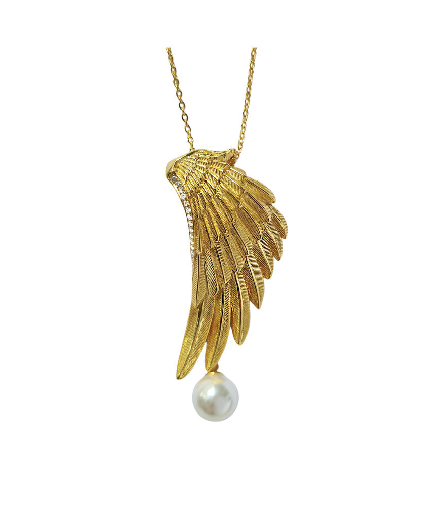 A gold vermeil wing pendant with a white pearl hanging from a dainty chain.