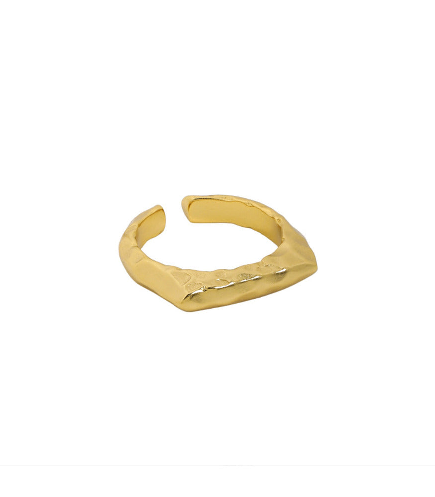 A gold plated sterling silver ring. The ring is a textured plateau open band ring. 