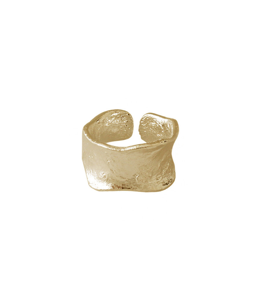 A gold vermeil open band ring. The ring has a thick band with a concave and brushed texture.  