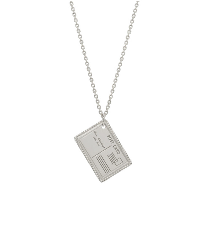 A sterling silver necklace with a postcard pendant. The pendant is engraved with details of a postcard.