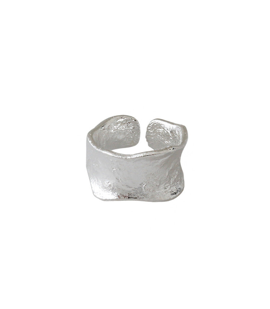 A sterling silver ring with a concave thick open band. The ring has a brushed texture. 