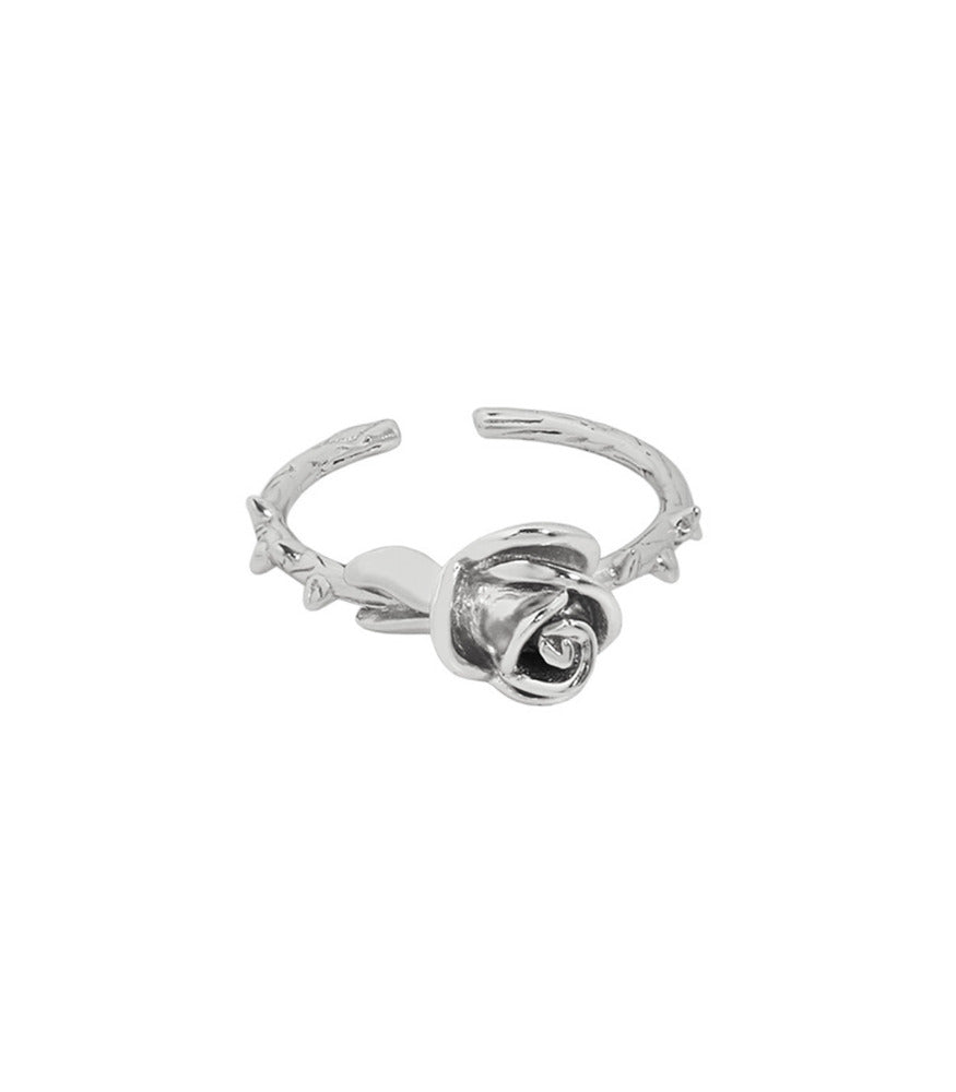 A sterling silver ring with a thorn detailing on the band and a detailed rose sitting at the top of the ring.