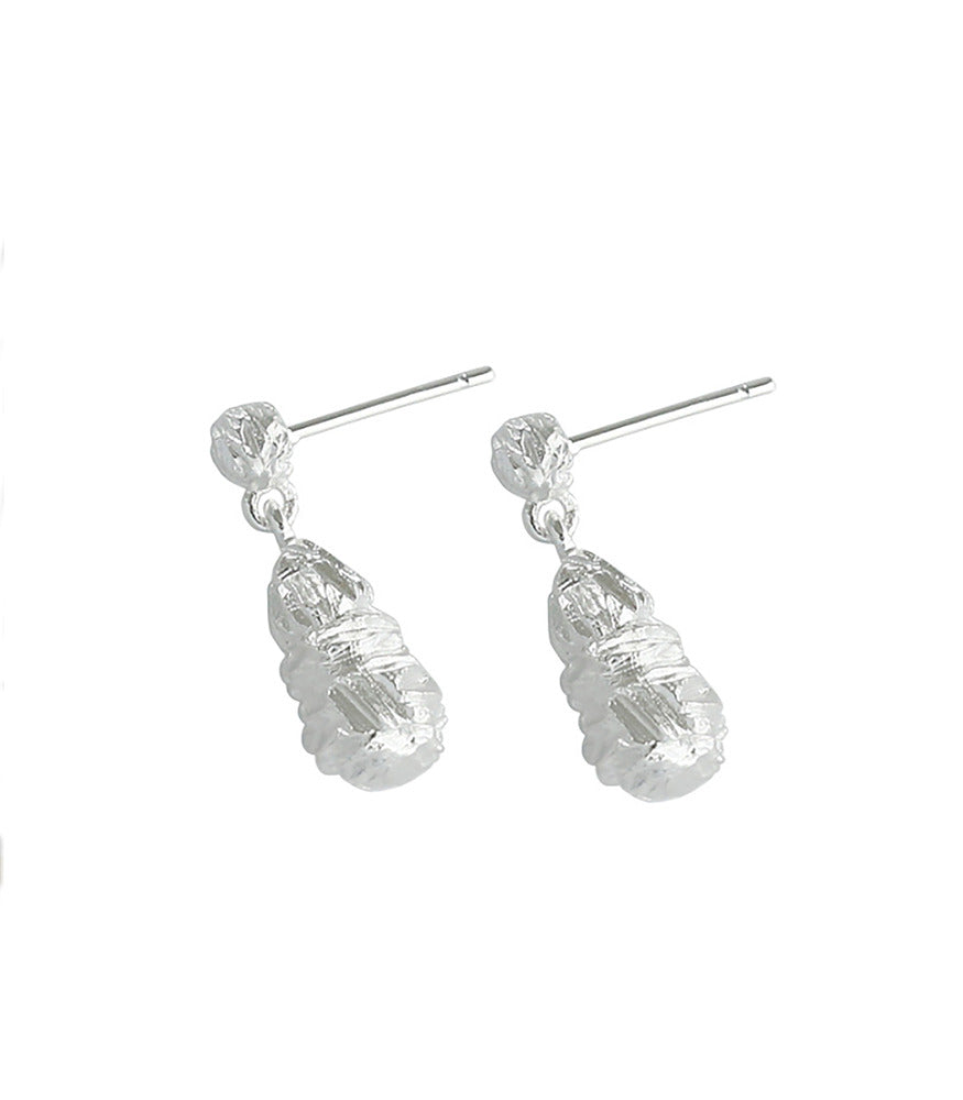 A pair of sterling silver earrings. The earrings are textured and closely resemble stalactites found in a cave.