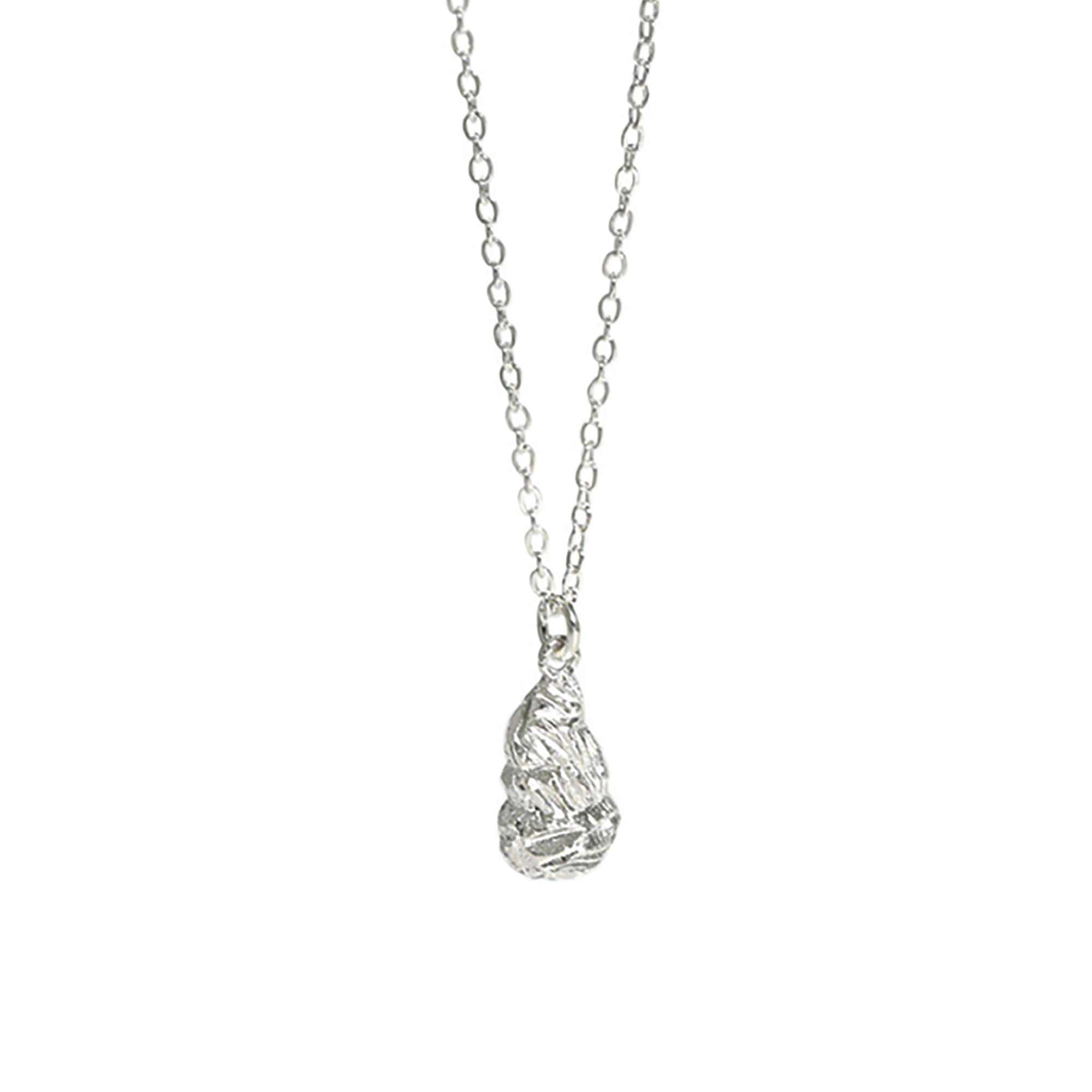 A sterling silver necklace with a dainty chain and hanging teardrop nugget which has a rocky texture.