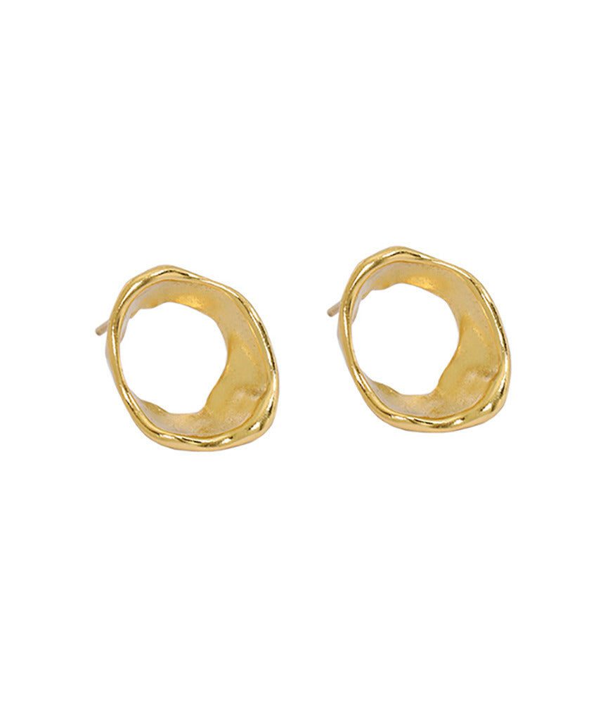 A pair of gold vermeil circle stud earrings. The earrings have an irregular shape, inspired by the movement of flowing water.