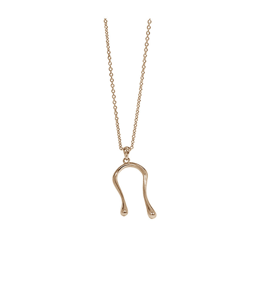 A gold vermeil necklace with a dainty chain and liquid curved pendant resembling water droplets.
