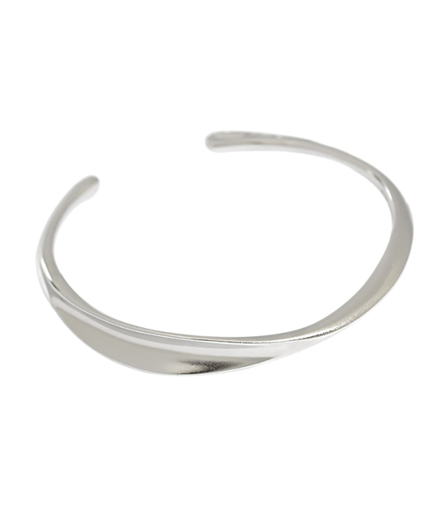 A smooth sterling silver bangle with a polished finish.