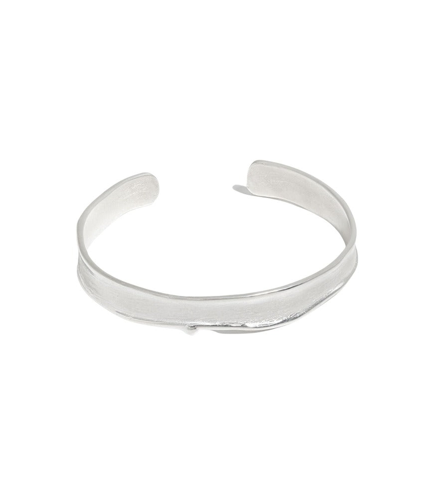A sterling silver bangle bracelet with a simple brushstroke texture.