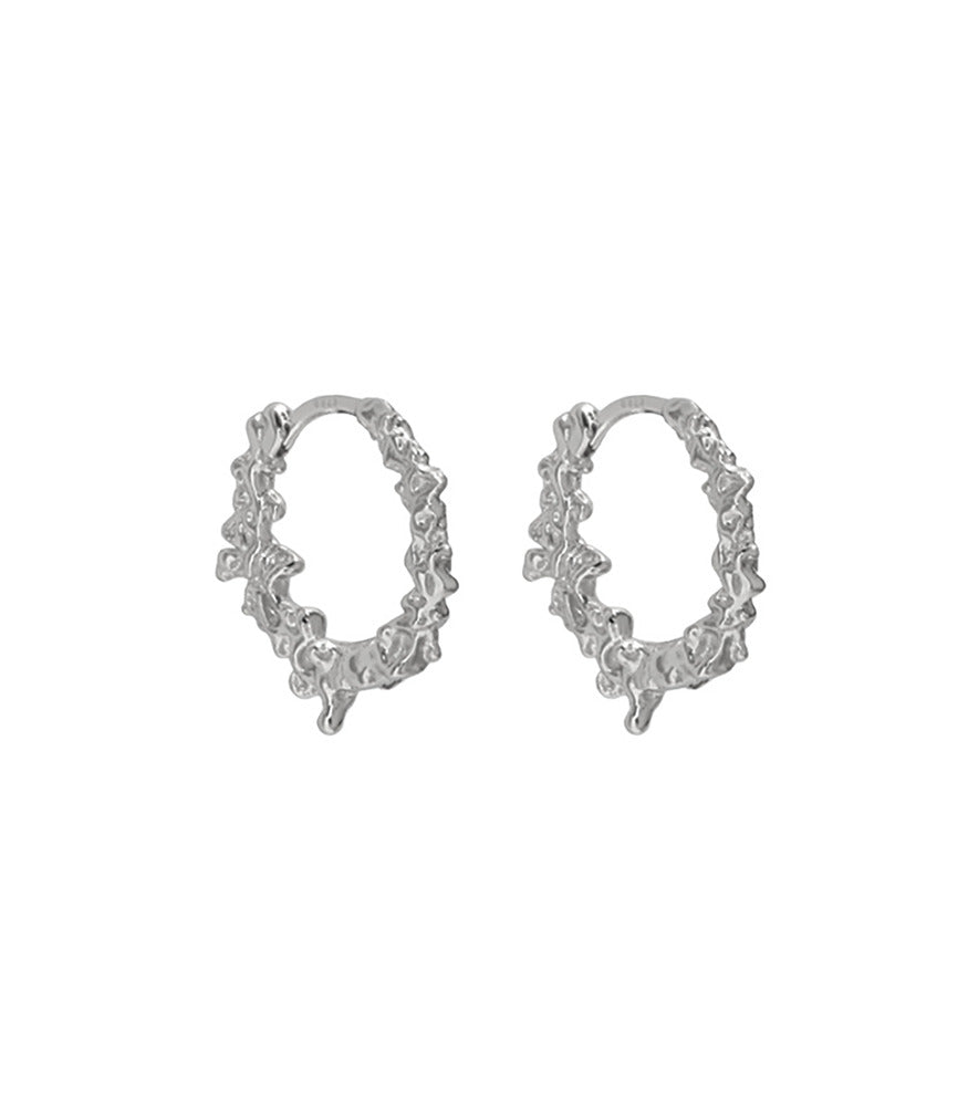 A pair of sterling silver textured hoop earrings. The detailing on the earrings closely resemble water droplets.